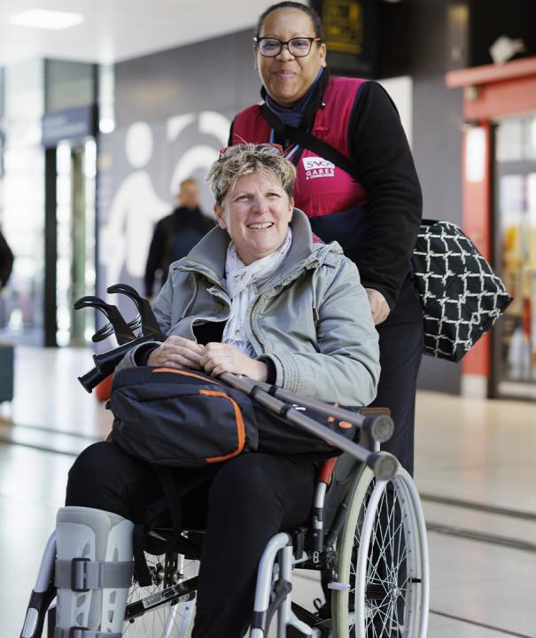 Agent SNCF assistant une personne en fauteuil roulant