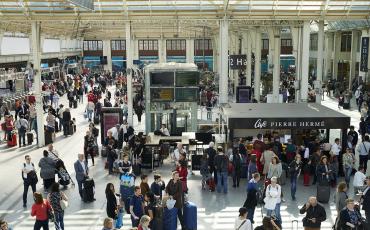 Hall intérieur d'une gare avec des voyageurs attendant leur train