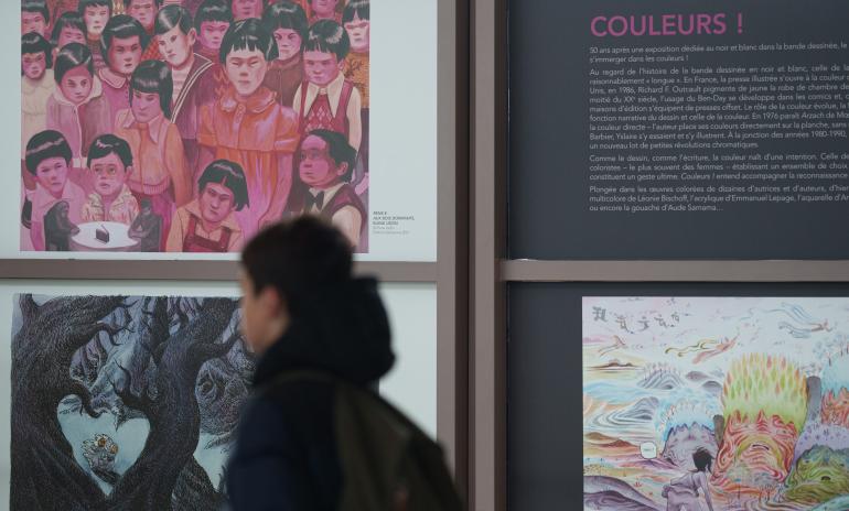 Photo des panneaux de l'exposition Couleurs! avec un enfant au premier plan qui passe devant.