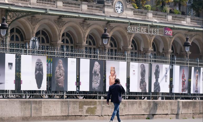 Panneaux représentant des statuettes apposés sur la grille de la gare de l'Est à Paris